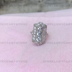 -------------------S p e c i f i c a t i o n s------------------- Specifics @Total Carat Weight (TCW): 2.20 carats @Main Stone Carat Weight: 1.50 carats @Main Stone Shape: Round cut @Side Stone Shape: Round @Main Stone Clarity: VVS1 @Cut Grade: Excellent @Metal: 925 Sterling Silver (Available in 14K white gold) You Will Receive @Engagement ring @Jewelry Box Moissanite Moissanite was introduced to the jewelry market in 1998 after Charles and Colvard received patents to create and market lab-grown silicon carbide gemstones, becoming the first firm to do so. They currently make their highest quality loose gems under the trademark Forever One. Generic moissanites are, as the name implies, brand less and are not protected by a registered trademark and are therefore more affordable. This does no Ring Jewelry Box, Pear Cut Diamond Ring, Jewelry Market, Three Stone Diamond Ring, Gold Solitaire Ring, Jewellery Marketing, Three Stone Diamond, Diamond Simulant, White Gold Diamond Rings