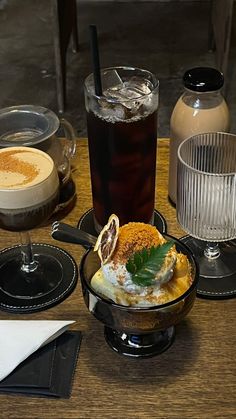 a table topped with drinks and desserts on top of plates next to glasses filled with liquid