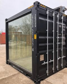 a large black container sitting on top of a dirt field