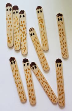 wooden pegs with faces on them are arranged in a row and one is painted brown