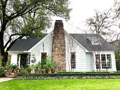 a white house surrounded by trees and flowers