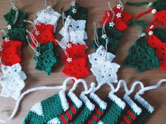 crocheted christmas stockings and stocking ornaments on a wooden table with white string