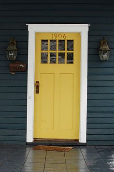 a yellow front door on a blue house