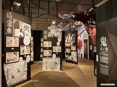 an art exhibit with black and white drawings on the walls, hanging from metal poles