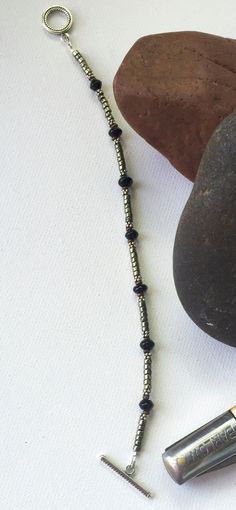 "Sterling Silver, Mens bracelet, Onyx bracelet, black onyx bracelet, beaded bracelet, men's bracelet, black onyx, gemstone bracelet, bracelet, black bracelet As shown this bracelet is 8-1/2\" [inches] long and approximately 1/8\" [inches} wide. I can make it in any 1/2\" size. It's made of genuine black Onyx, Sterling silver (.925) , Pyrite and African copper, and finished off with a sterling silver (.925) toggle clasp. I love designing jewelry for men! I always imagine the kind of man that woul Silver Onyx Beaded Bracelet With Black Beads, Minimalist Silver Beaded Bracelet With Black Beads, Silver Minimalist Hematite Jewelry, Minimalist Silver Hematite Jewelry, Silver Hematite Beaded Bracelets With Black Beads, Silver Hematite Bracelets With Gemstone Beads, Silver Mens Bracelet, Designing Jewelry, Pyrite Bracelet