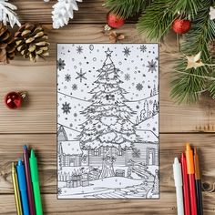 a christmas tree is on the table next to colored pencils and other holiday decorations