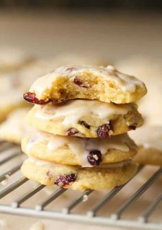 a stack of cookies with icing and cranberries sitting on a cooling rack