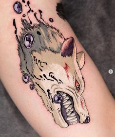 a tattoo with an animal's head on the arm and eyes painted on it