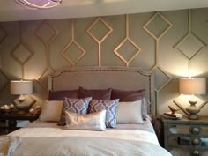 a large bed sitting under two lamps on either side of the headboard and foot board