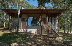 a small house in the woods with stairs leading up to it's roof and windows