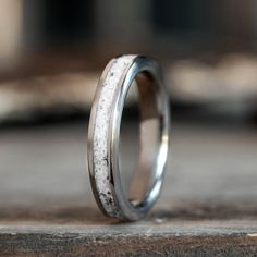 a close up of a wedding ring on a wooden surface