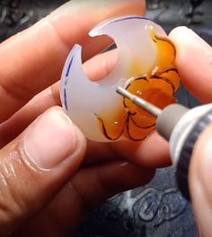 someone is working on something with glass in the shape of a crescent and flowers,