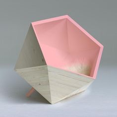 a pink and white vase sitting on top of a wooden stand