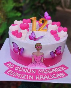 a birthday cake decorated with pink butterflies and the number twelve on it's side