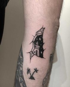 a man's arm with a house and palm trees tattoo on it