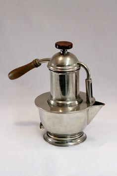 a silver coffee pot with a wooden handle