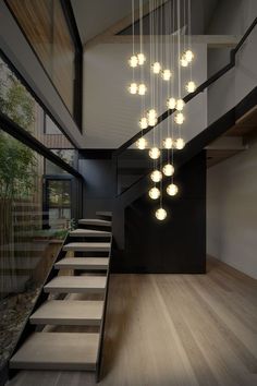 a modern chandelier hanging from the ceiling in a room with wood flooring