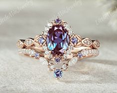 this is an image of a ring with a purple stone in the center and white diamonds around it