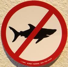 a no shark sign is shown on the side of a white wall with a red circle