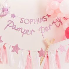 a party banner with pink tassels and balloons in the background that says sophias pamper party