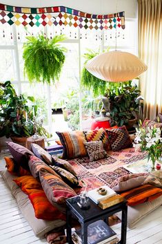 a living room filled with lots of furniture and plants on top of the windowsill