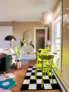 a living room filled with furniture and a checkered rug on top of a hard wood floor