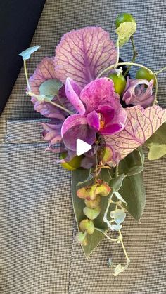 purple flowers and green leaves in a vase