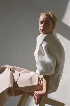 a woman sitting on top of a wooden chair