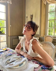 a woman sitting at a table with plates on it