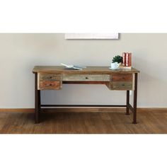 a wooden desk sitting on top of a hard wood floor next to a white wall