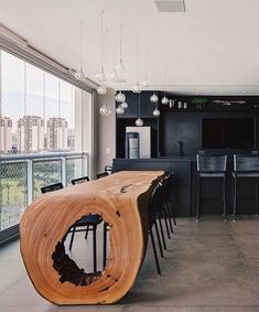 a large wooden table sitting in the middle of a living room next to a kitchen