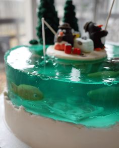 there is a cake with green frosting on the top and two fish in the bottom