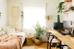 a bed room with a neatly made bed next to a desk and two computer monitors