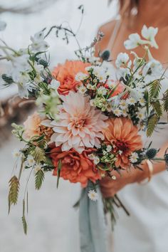 a woman holding a bouquet of flowers in her hands