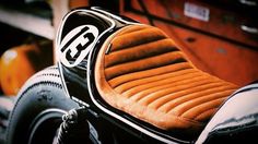 an orange and black motorcycle seat with the number 35 on it's back end