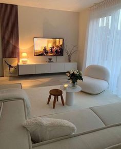 a living room filled with furniture and a flat screen tv on top of a wall