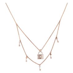 The Lock & Key Diamond Charms Necklace is a stunning piece of jewelry made from 18k solid gold. It features a double-layered design, with one layer showcasing a lock charm and another featuring key charms. The lock pendant is adorned with exquisite diamonds, adding a touch of elegance and sparkle to the necklace. The dual-tone design adds visual interest, with one layer in yellow gold and the other in white gold, creating a beautiful contrast. THE STONES- This necklace consists of a round diamon Luxury Double Chain Double Strand Jewelry, Luxury Double Strand Double Chain Jewelry, Luxury Chain Necklace With Detachable Pendant, Luxury Hallmarked Rose Gold Diamond Necklace, Luxury Yellow Gold Necklaces With Double Chain, Luxury Yellow Gold Double Chain Necklace, Luxury Yellow Gold Necklace With Double Chain, Luxury Yellow Gold Jewelry With Double Chain, Luxury Pendant Chain Necklace With Charms