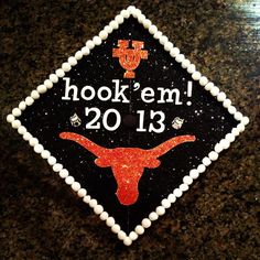 a black and white graduation cap with an orange longhorn on it