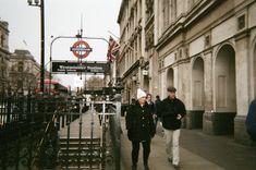 two people walking down the street in london