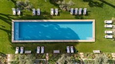 an aerial view of a swimming pool surrounded by lawn chairs