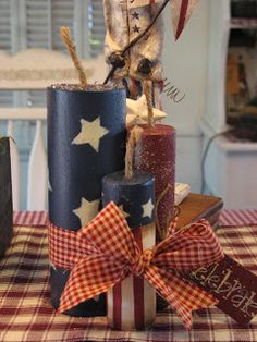 a table topped with candles and decorations on top of a red white and blue checkered table cloth