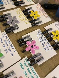 several pieces of paper with flowers and words on them sitting on a table next to each other