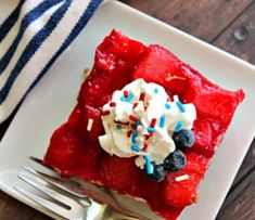 a piece of red velvet cake topped with whipped cream and blueberries on a white plate