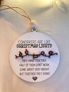 a christmas ornament hanging from a string with words on it that read, workers are like christmas lights they hang together half of them don't work some aren't very bright