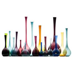 many different colored vases are lined up in a row on a white background,