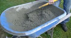 a man holding a wheelbarrow filled with dirt