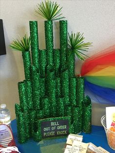 a table topped with lots of green glitter bottles and palm trees on top of it