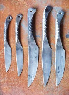 five knives are lined up on a table