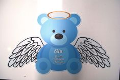 a blue teddy bear with angel wings on it's chest and the words glo all around