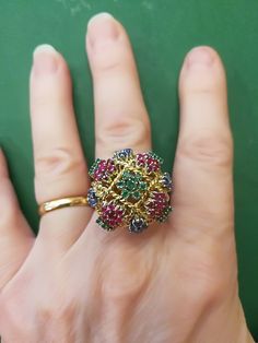 "Beautiful, unique, outrageous vintage18K multi stone ring. There is no karat stamp, but has been tested as 18K. It weighs 14.8 grams, and is set with the following approximate weights of stones: .30 ctw genuine emeralds, .59 ctw genuine sapphires, and .70 ctw genuine rubies. It is between a size 7 1/2 and 8. It has \"bumps\" inside the ring which leave a small gap, when measuring it in a mandrel. There is one flaw in the ring. There is a missing emerald, due to a broken prong. I have this area Luxury Multi-stone Cluster Ring, Multicolor Multi-stone Emerald Oval Ring, Multicolor Multi-stone Cluster Ring As Gift, Elegant Multicolor Ruby Ring, Multicolor Ruby Ring For Formal Occasions, Elegant Multicolor Cluster Ring As Gift, Elegant Multicolor Cluster Ring For Gift, Unique Multi-stone Emerald Ring For Formal Occasions, Vintage Multicolor Rings For Jewelry Making